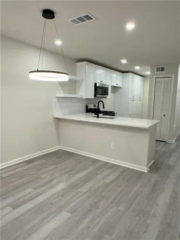 a kitchen with kitchen island a sink and a stove