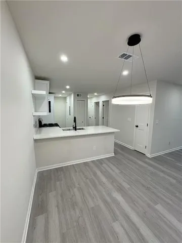 a large white kitchen with a white countertops and a fireplace