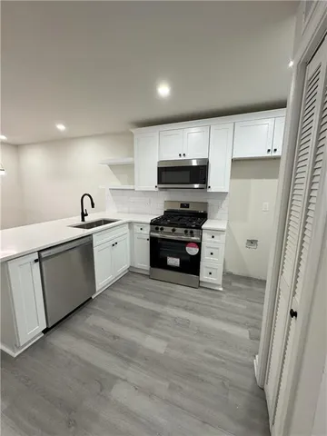 a kitchen with stainless steel appliances a sink a stove a refrigerator and cabinets