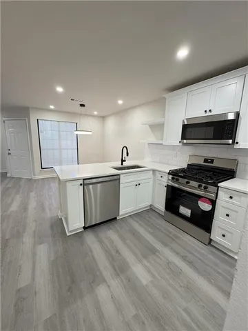 a kitchen with stainless steel appliances a stove a sink a refrigerator and cabinets