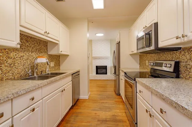 a large kitchen with stainless steel appliances granite countertop a lot of counter space and a sink