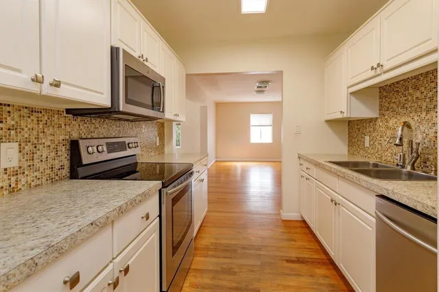 a kitchen with stainless steel appliances granite countertop a stove a sink and a microwave