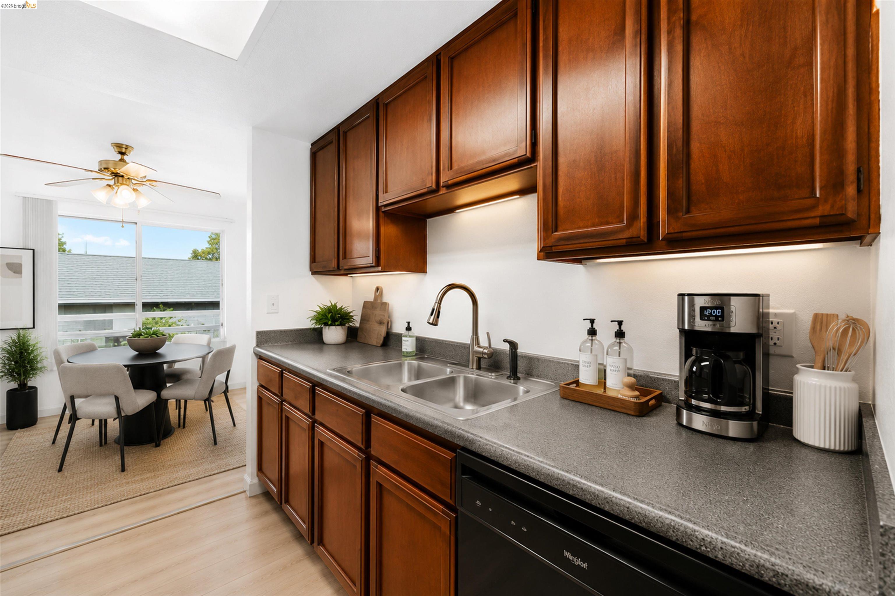 4186 San Pablo Dam Road, Unit A El Sobrante, CA 94803 - Photo 18 of 34 Kitchen featuring wood cabinetry, a dual basin stainless steel sink with a high-arc faucet, and dark countertops
