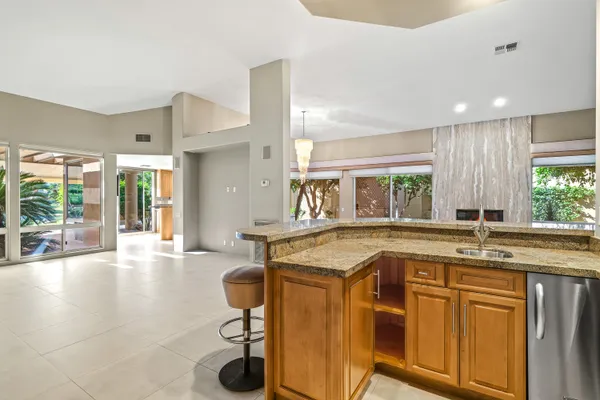 a large kitchen with kitchen island granite countertop a large window and stainless steel appliances