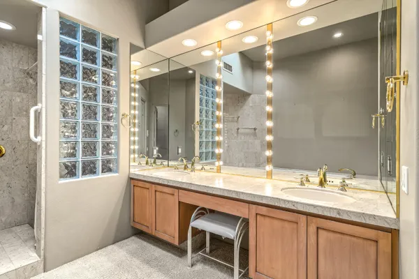 a bathroom with a sink a large mirror and a shower