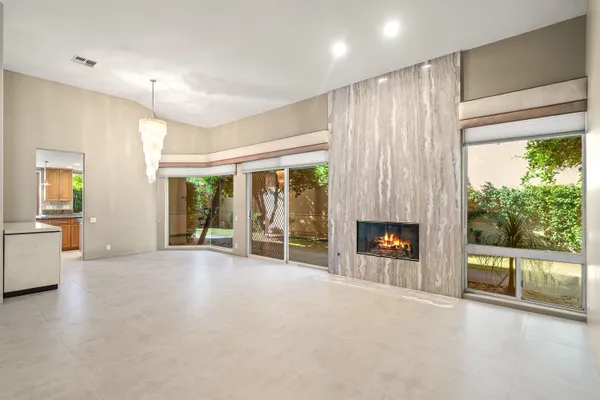 a view of an empty room with a fireplace and a window