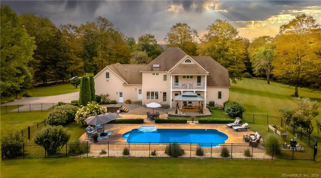 a aerial view of a house with swimming pool lawn chairs and a yard