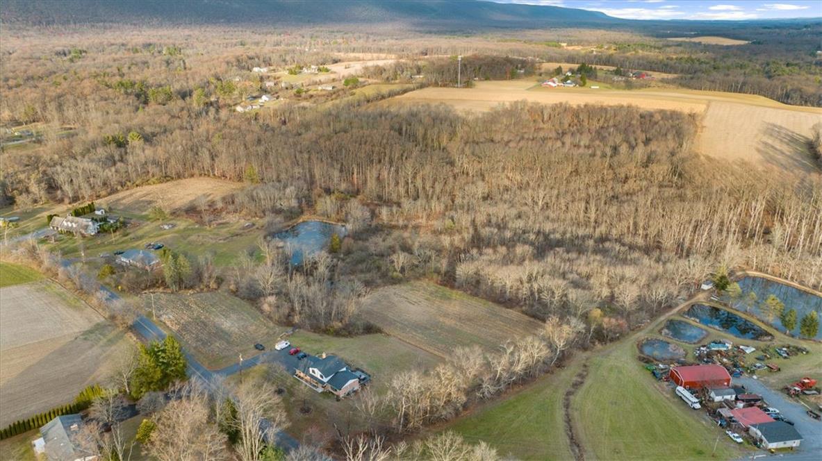 988 Hoch Road Danielsville, PA 18038 - Photo 25 of 29 An aerial panorama reveals a vast, serene lot encompassing wooded areas, open fields, and multiple ponds.