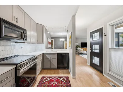 a kitchen with stainless steel appliances kitchen island granite countertop a refrigerator stove top oven and sink