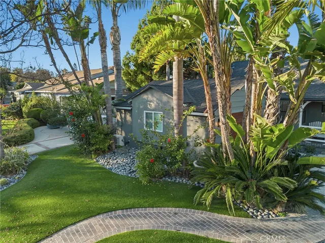 a view of a house with a tree and plants