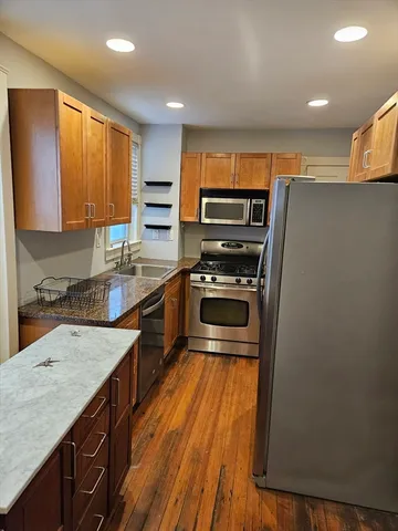 a kitchen with wooden cabinets and stainless steel appliances