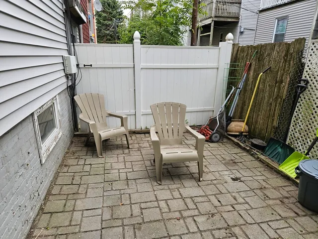 a view of a patio with table and chairs with wooden floor and fence