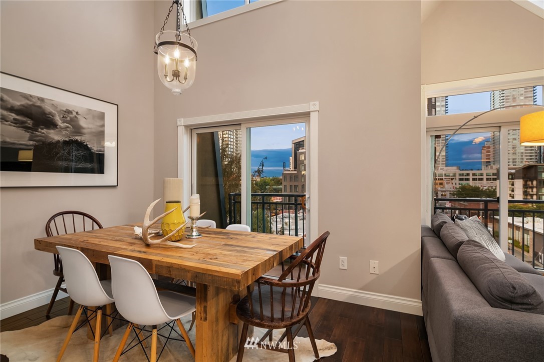 2415 2nd Avenue, Unit 734 Seattle, WA 98121 - Photo 6 of 23 a view of a dining room with furniture wooden floor and a chandelier