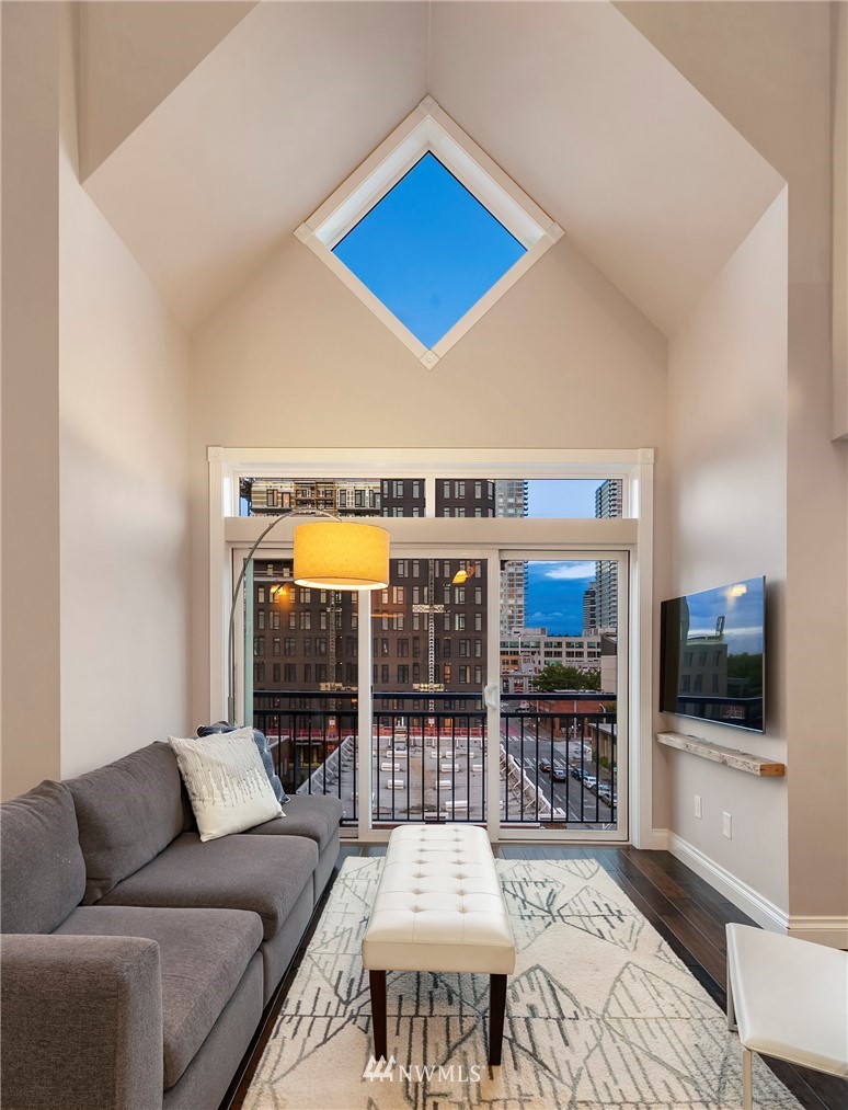 2415 2nd Avenue, Unit 734 Seattle, WA 98121 - Photo 10 of 23 a living room with furniture flat screen tv and a floor to ceiling window
