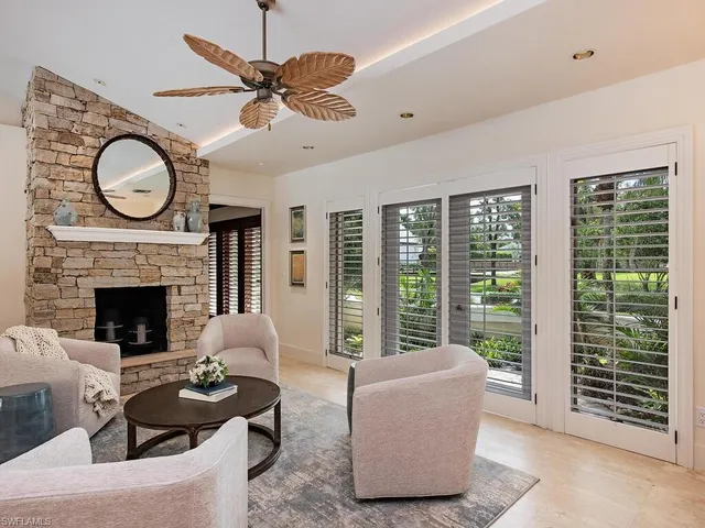 a living room with furniture a fireplace and a large window