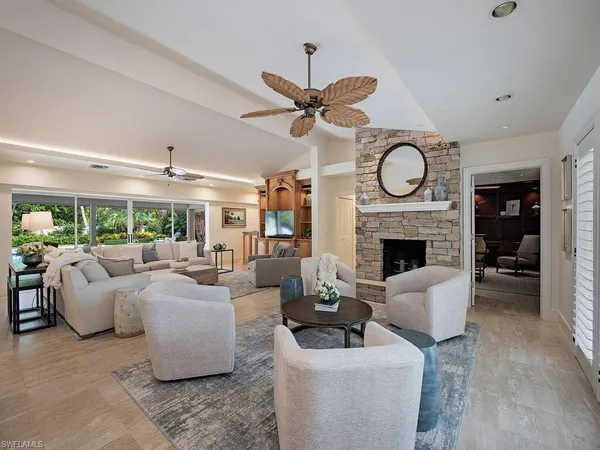 a living room with furniture a fireplace and a large window