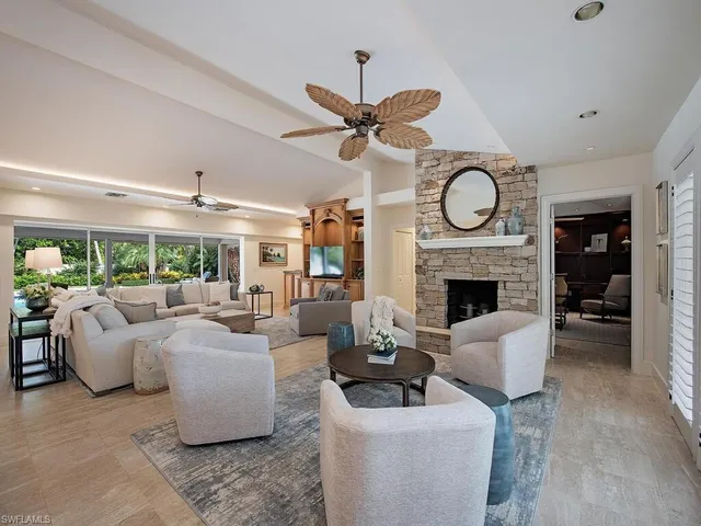 a living room with furniture a fireplace and a large window