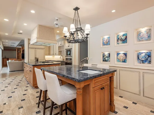 a kitchen with stainless steel appliances granite countertop a kitchen island a stove a table and chairs in it