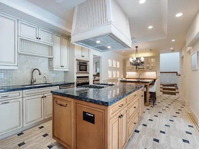 a kitchen with stainless steel appliances granite countertop a sink a stove and a refrigerator