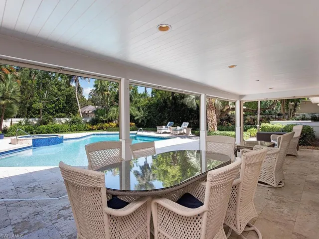 a dining room with furniture and floor to ceiling window