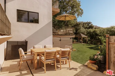 a patio with a table and chairs under an umbrella