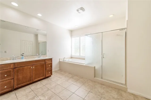 a spacious bathroom with a double vanity sink a mirror and a bathtub