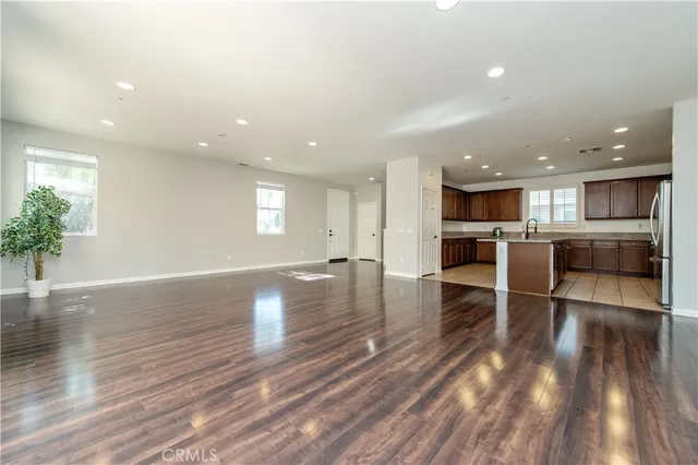 a view of a kitchen with dining table stainless steel appliances cabinets table and chairs