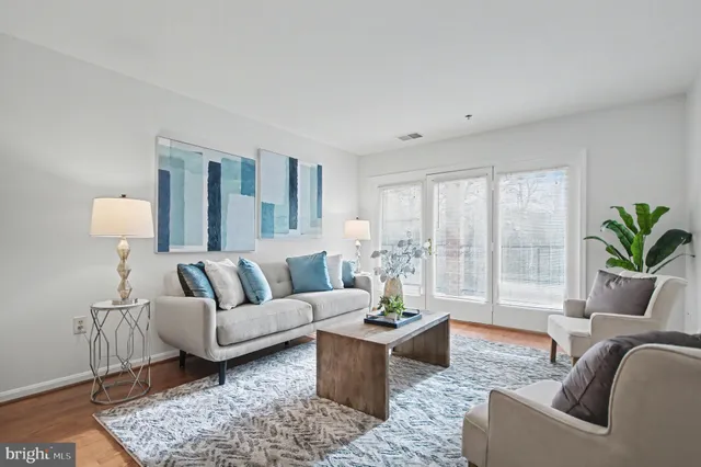 a living room with furniture and a potted plant on table