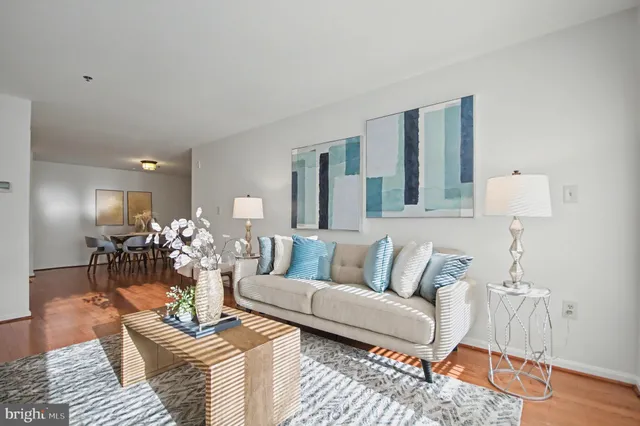 a living room with furniture a lamp and wooden floor
