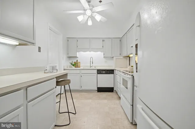 a kitchen with white cabinets and white appliances