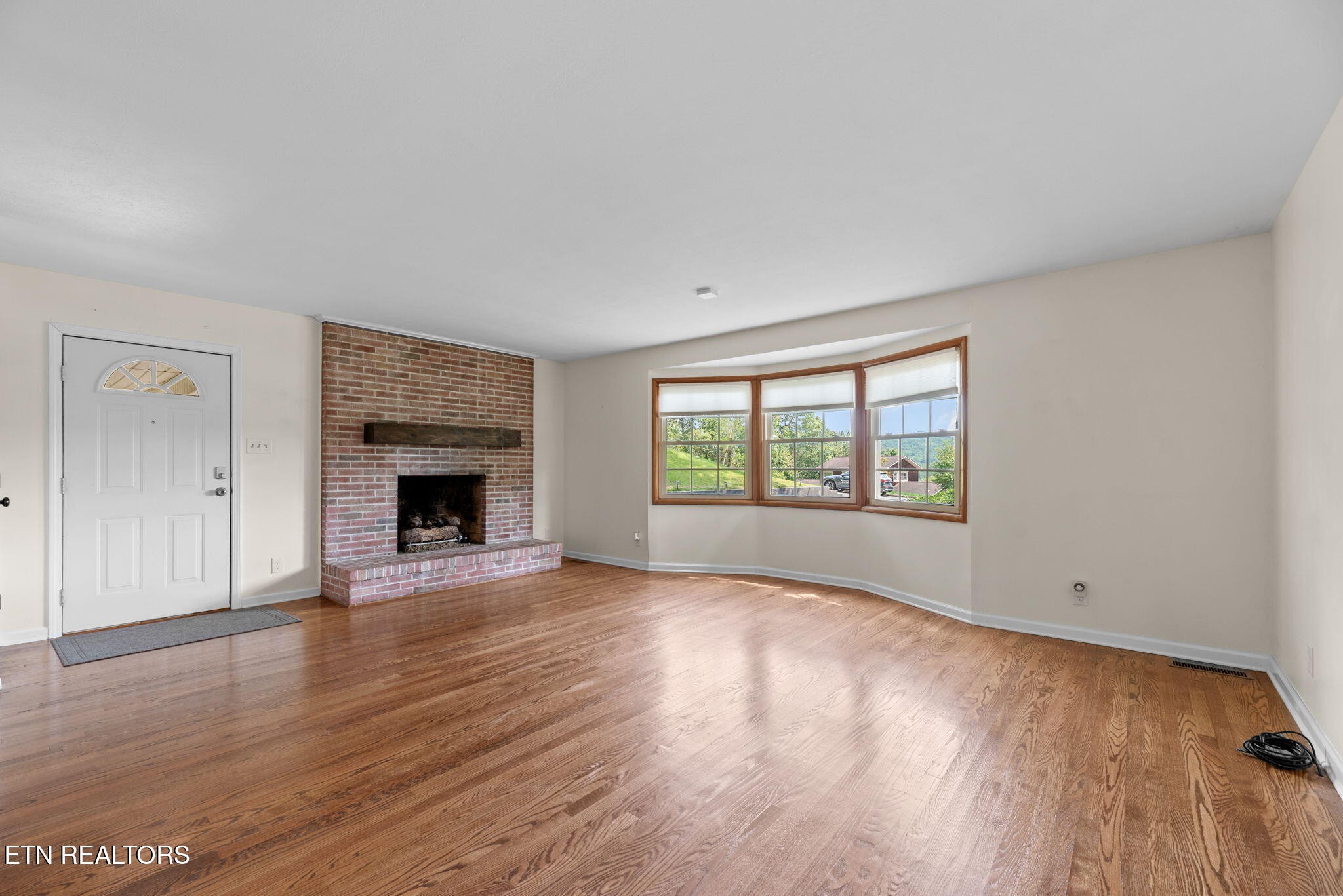 114 Canterbury Road Oak Ridge, TN 37830 - Photo 5 of 42 a view of empty room with wooden floor and fireplace