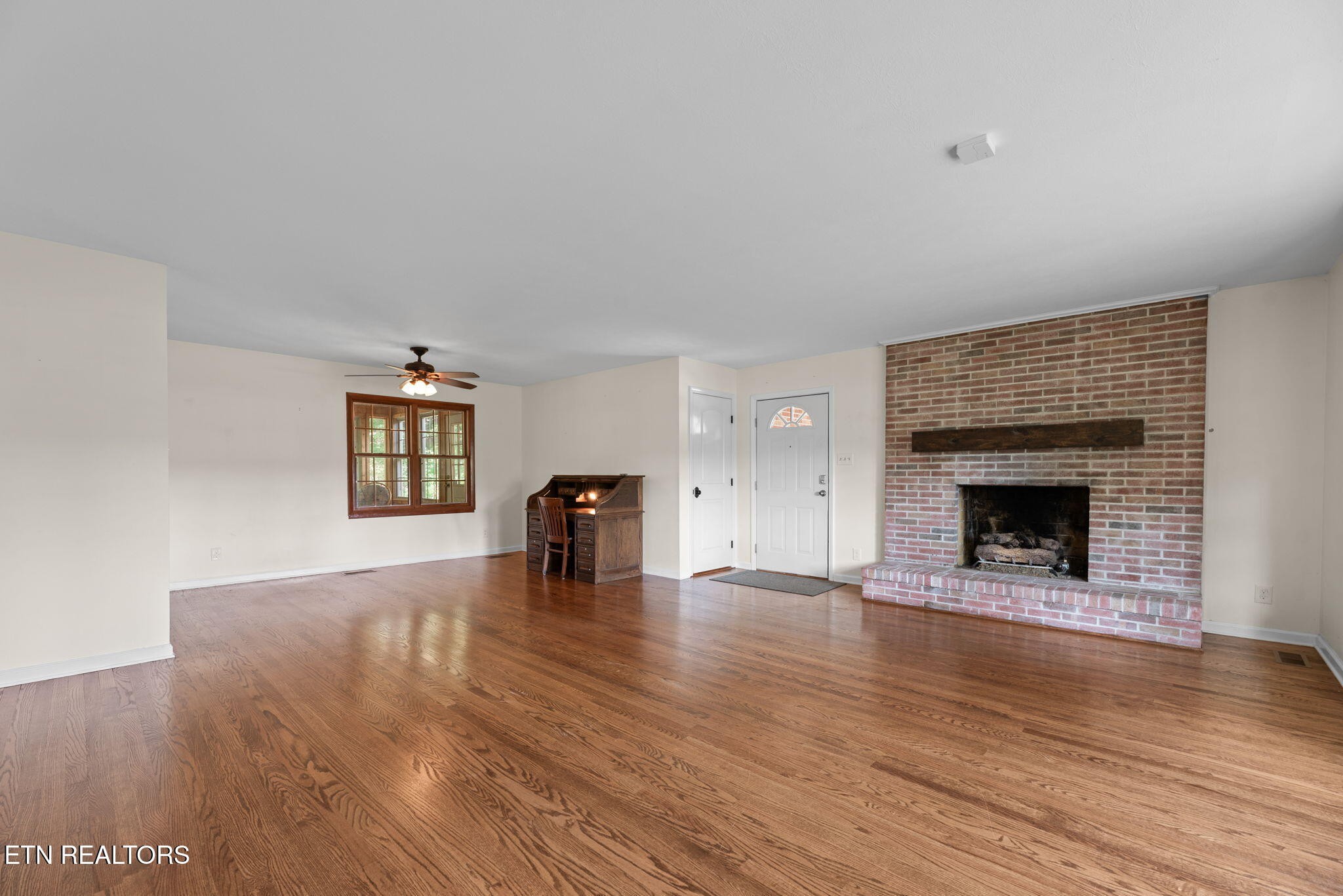 114 Canterbury Road Oak Ridge, TN 37830 - Photo 7 of 42 a view of an empty room with wooden floor fireplace and a window
