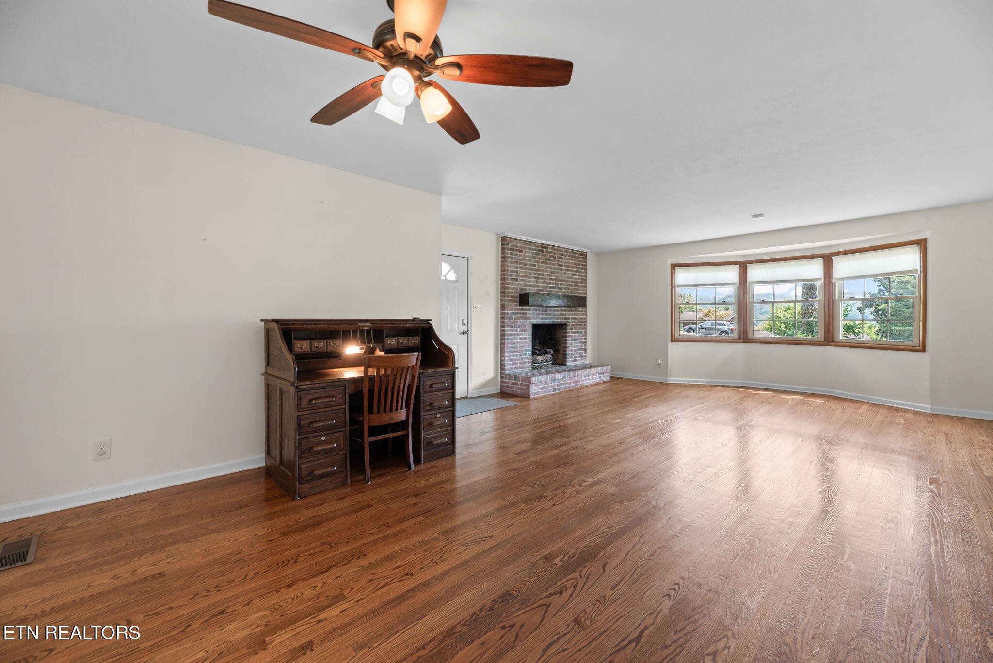 114 Canterbury Road Oak Ridge, TN 37830 - Photo 9 of 42 an empty room with wooden floor fan and windows