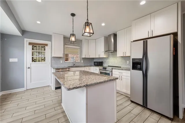 a kitchen with stainless steel appliances granite countertop a sink stove and refrigerator