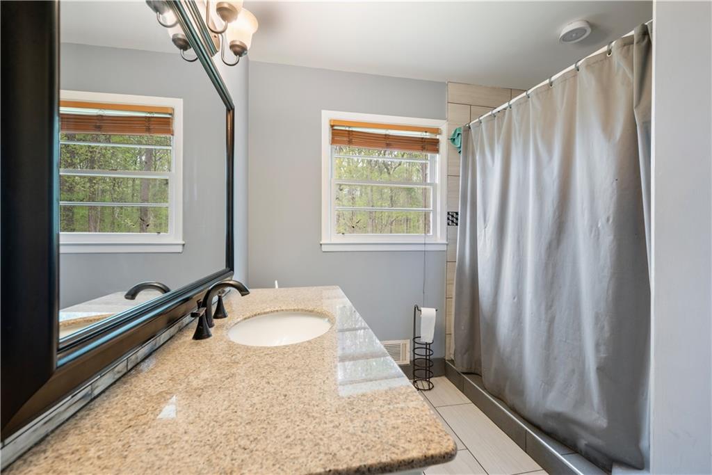 4329 Cedar Valley Lane Conley, GA 30288 - Photo 11 of 25 a bathroom with a granite countertop sink and a mirror