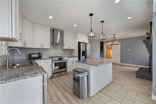a kitchen with stainless steel appliances granite countertop a sink stove and refrigerator