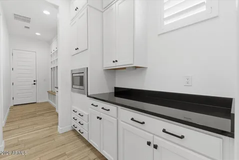 a kitchen with granite countertop white cabinets and stainless steel appliances