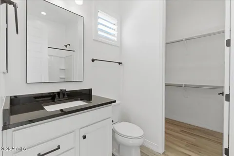 an empty room with wooden floor cabinet and windows