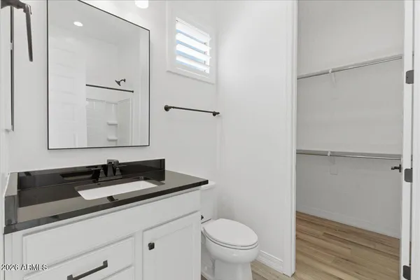 an empty room with wooden floor cabinet and windows
