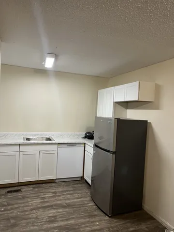 a view of a refrigerator in kitchen and wooden floor