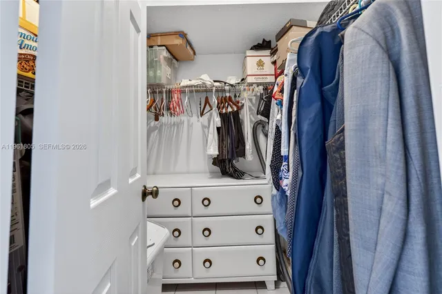 a view of walk in closet with clothes and shoes