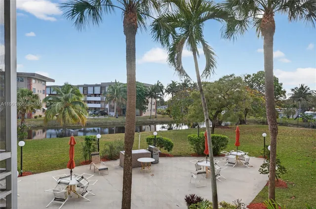 a row of palm trees and swimming pool in the backyard of a building