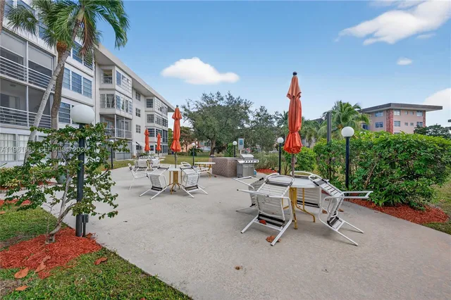 a view of a patio with a table and chairs and potted plants