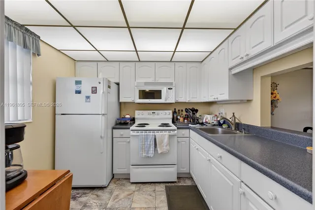 a kitchen with stainless steel appliances a refrigerator sink and cabinets
