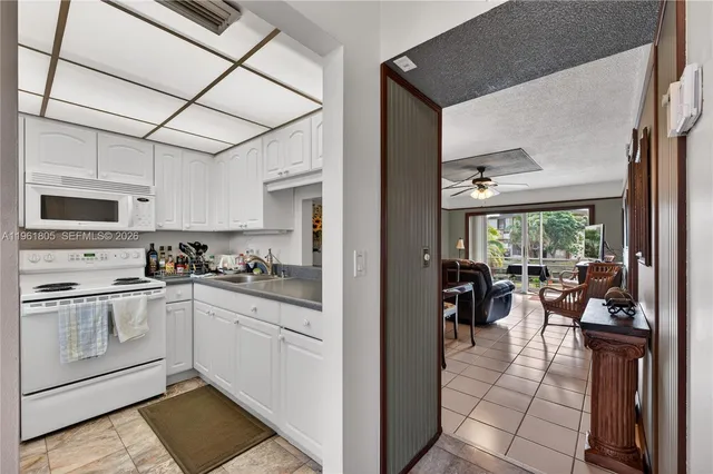 a kitchen with stainless steel appliances granite countertop a stove top oven a sink dishwasher a dining table and chairs with wooden floor