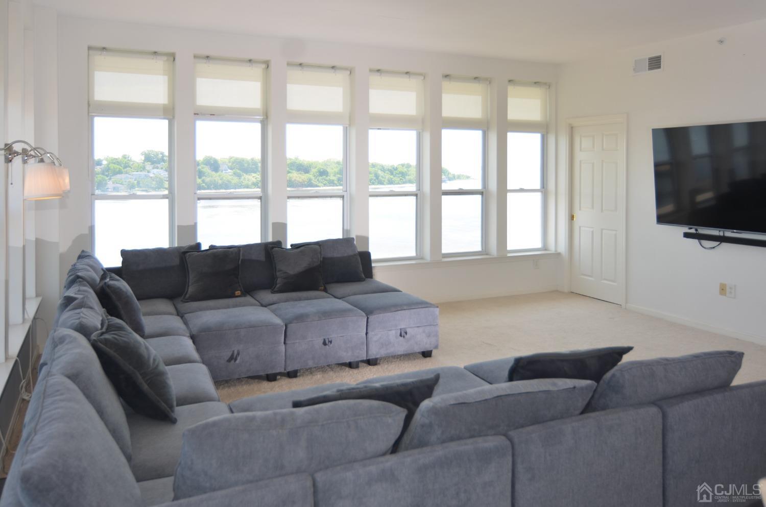 358 Rector Street, Unit 710 Perth Amboy, NJ 08861 - Photo 4 of 35 a living room with furniture and a flat screen tv