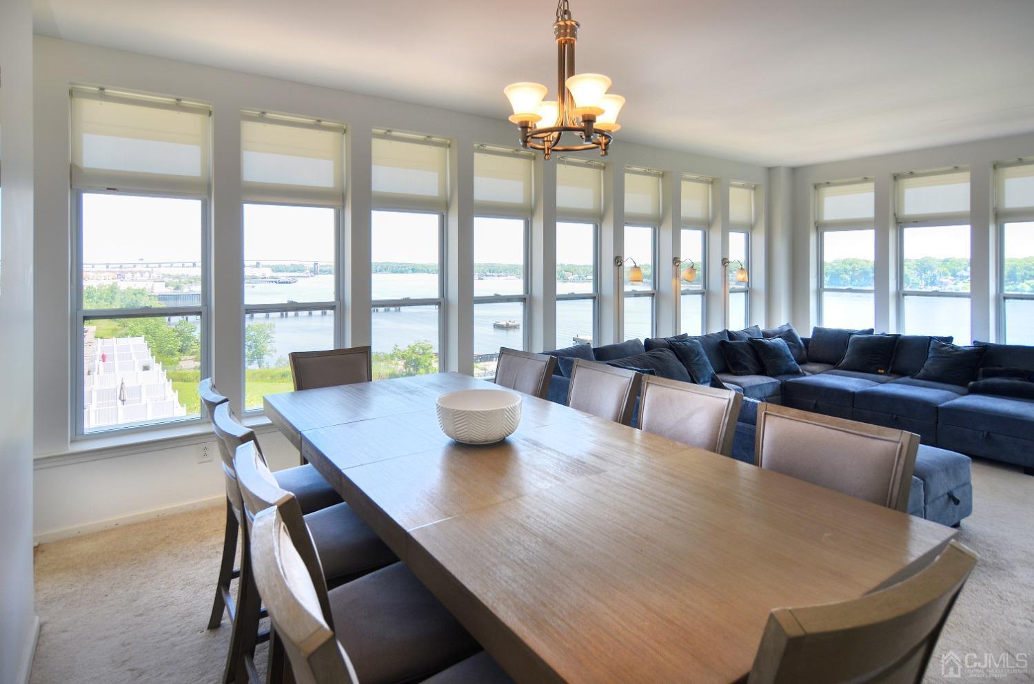 358 Rector Street, Unit 710 Perth Amboy, NJ 08861 - Photo 6 of 35 a view of a dining room with furniture a chandelier and large windows