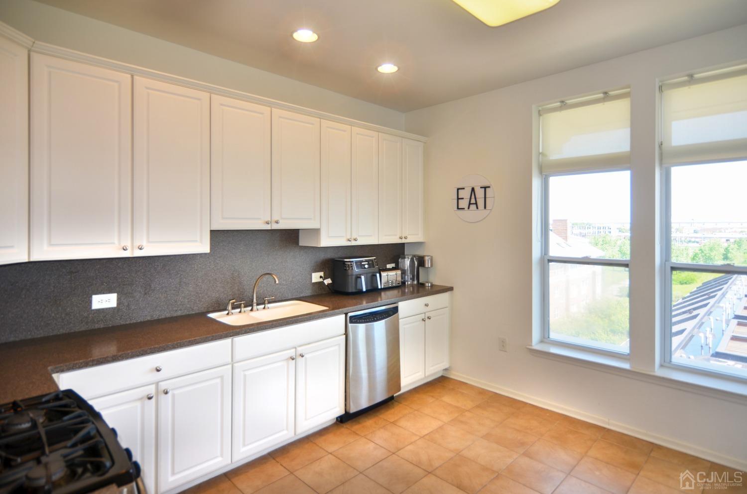 358 Rector Street, Unit 710 Perth Amboy, NJ 08861 - Photo 8 of 35 a kitchen with granite countertop white cabinets and white appliances
