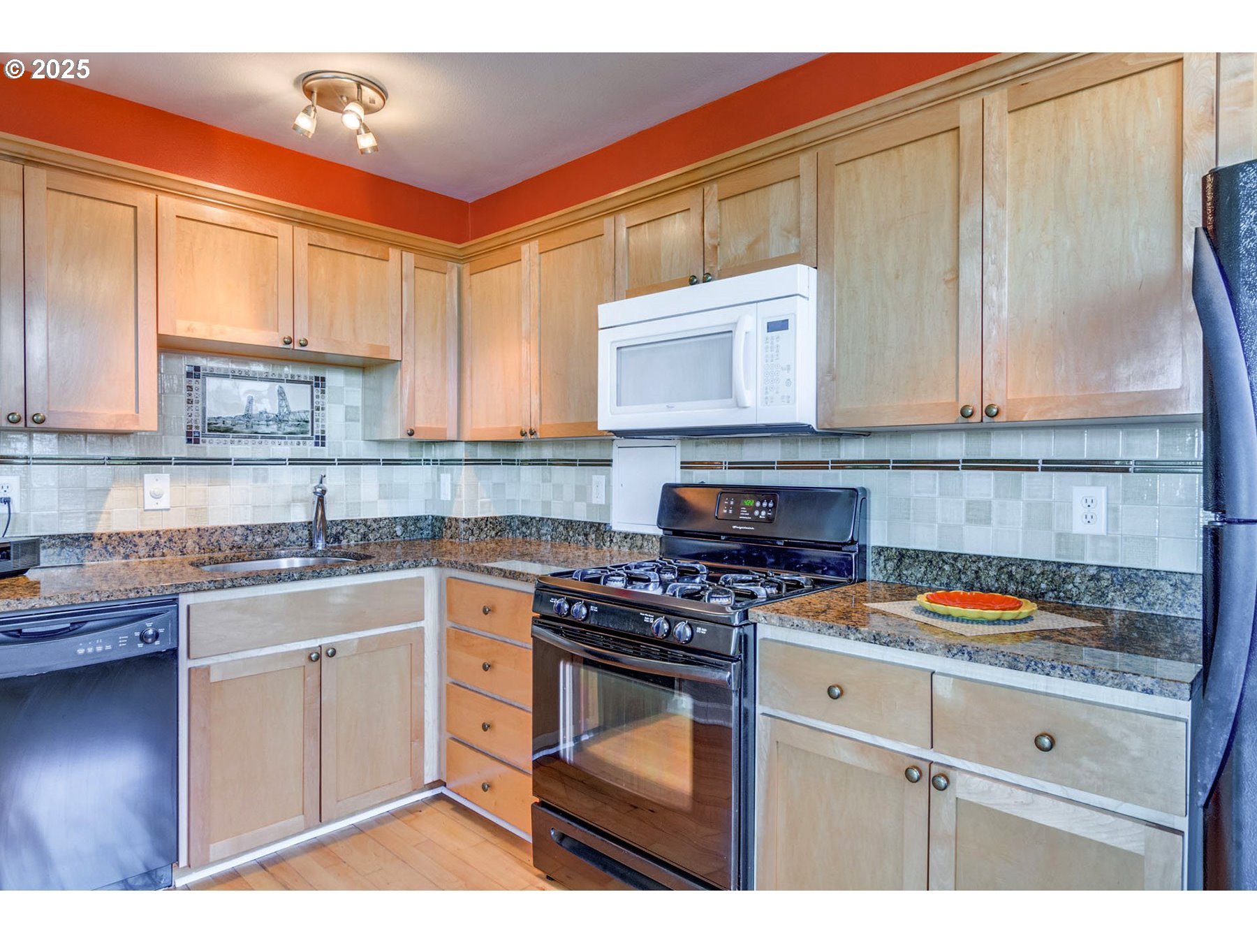 1205 Southwest Cardinell Drive, Unit 302 Portland, OR 97201 - Photo 11 of 23 a kitchen with stainless steel appliances granite countertop a stove a sink and a microwave