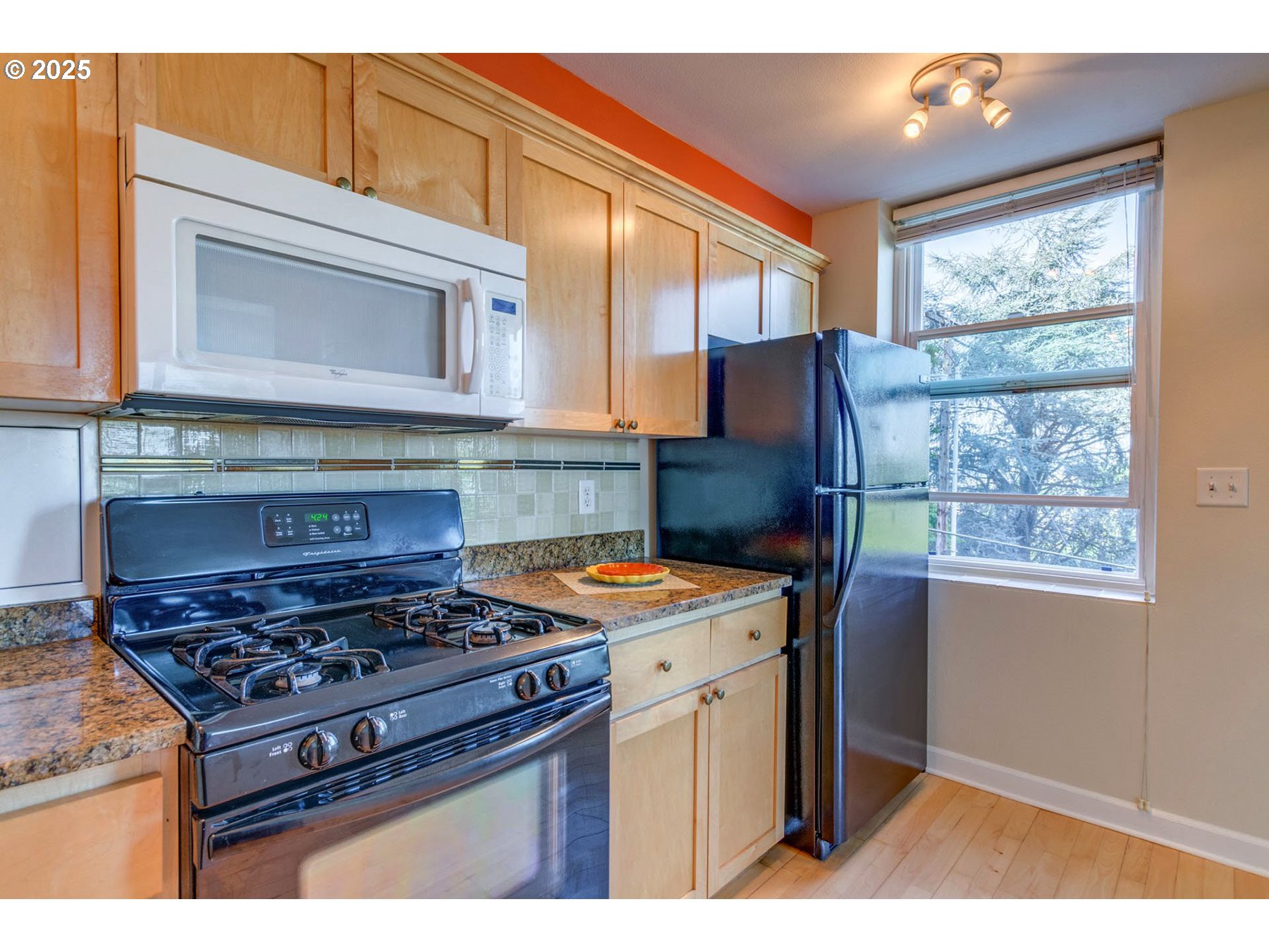 1205 Southwest Cardinell Drive, Unit 302 Portland, OR 97201 - Photo 13 of 23 a kitchen with stainless steel appliances granite countertop a stove a sink and a microwave